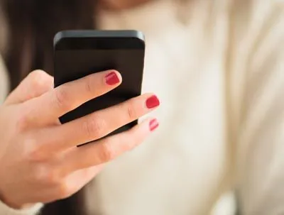 woman holding her phone about to call her dentist