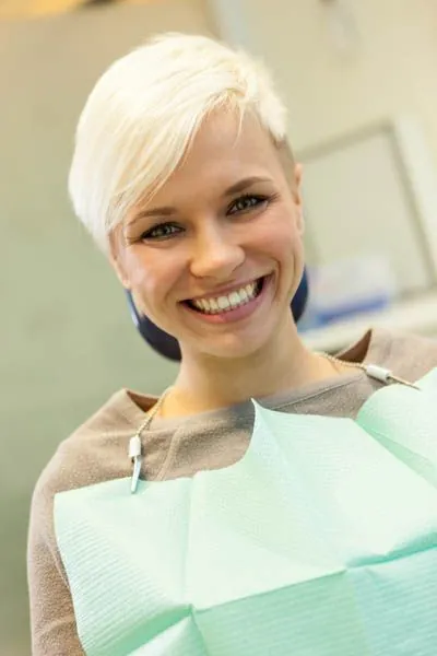 woman smiling in the dental chair after getting her teeth cleaned