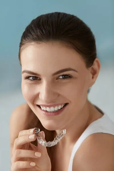 woman holding her Invisalign clear aligners